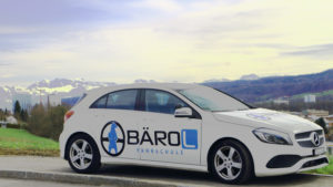 Fahrschulauto vor den Bergen in der Schweiz